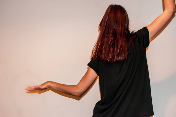 Uma visão traseira close-up de uma jovem mulher ruiva caucasiana irreconhecível tomada enquanto ela está dançando
 - Foto, Imagem