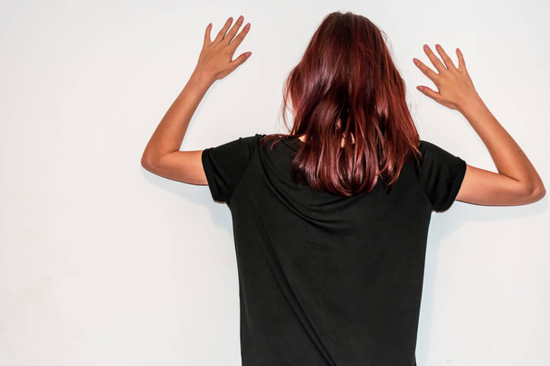 Uma visão traseira close-up de uma jovem mulher ruiva caucasiana irreconhecível com as mãos levantadas no ar
 - Foto, Imagem