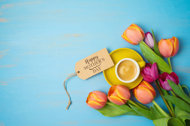 Happy Mother's day concept with coffee cup and beautiful tulip flowers on wooden background. Top view from above - Foto, Imagem