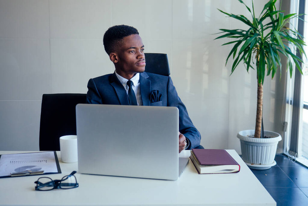 Handsome cheerful african american in a modern office with a panoramic window - Foto, afbeelding