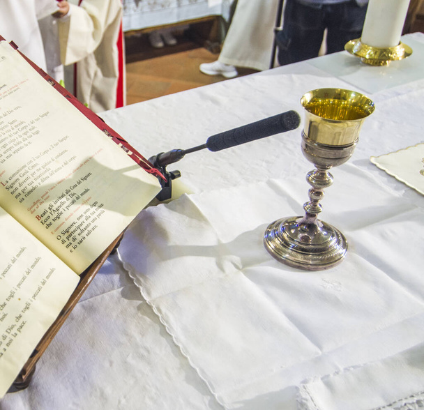 cálice com vinho, consagrado no sangue de Cristo ressuscitado, pronto para a comunhão dos fiéis durante a missa
 - Foto, Imagem