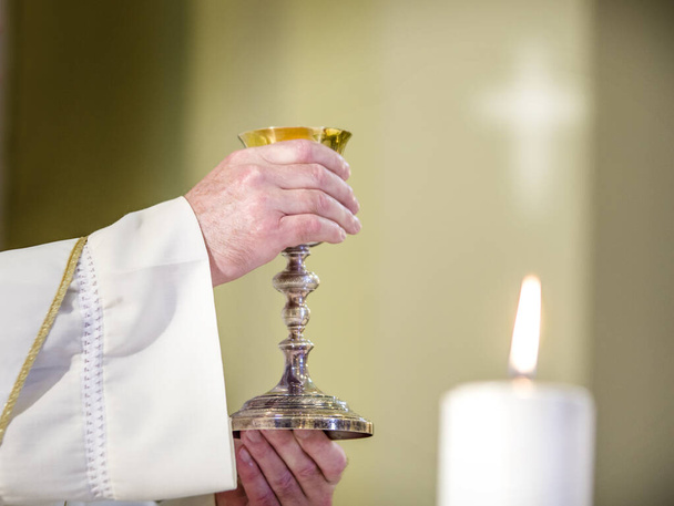cáliz con vino, consagrado en la sangre de Cristo resucitado, listo para la comunión de los fieles durante la misa
 - Foto, imagen