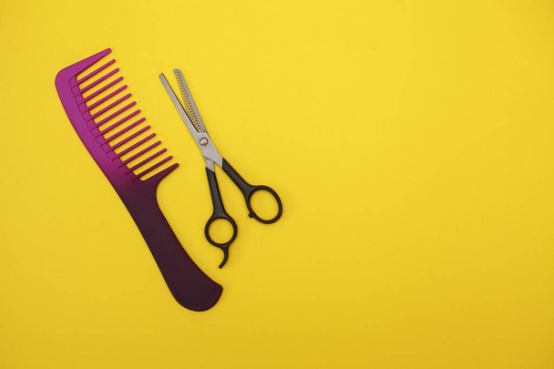 thinning scissors and a purple comb for hair on a yellow background, space for text. Barber Tools. flat lay - Fotografie, Obrázek