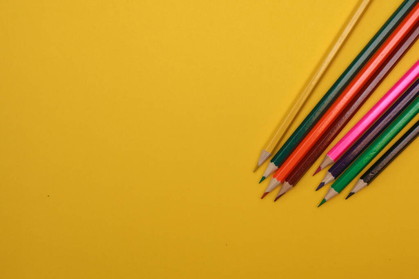 Colored pencils on a yellow background, space for text. Flat lay. - Foto, immagini