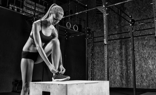 Fitness woman tying sneakers in gym - Fotoğraf, Görsel
