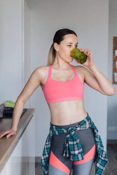 Young woman drinking a glass of water after workout - Foto, imagen