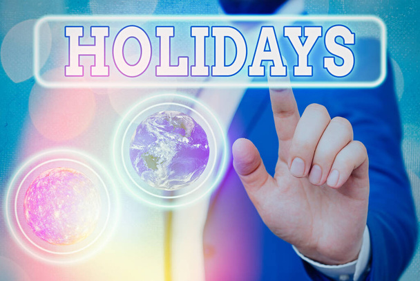 Text sign showing Holidays. Conceptual photo an extended period of leisure and recreation spent away from home Elements of this image furnished by NASA. - Photo, Image