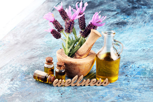 lavender herbal oil and lavender flowers. bottle of lavender massage oil for aromatherapy beauty treatment and wellness letters made of wood - Photo, Image