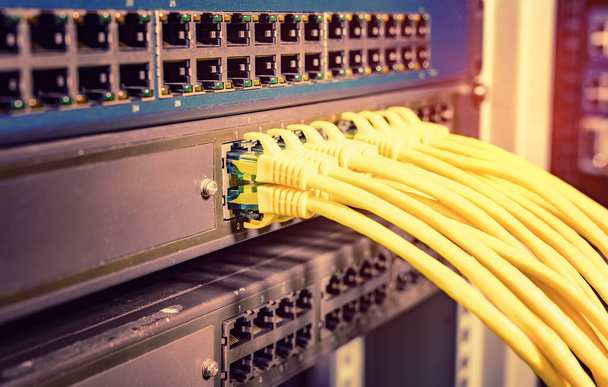 Gelbes Netzwerkkabel im Switch und Firewall im Rack des Cloud Computing Rechenzentrums - Foto, Bild
