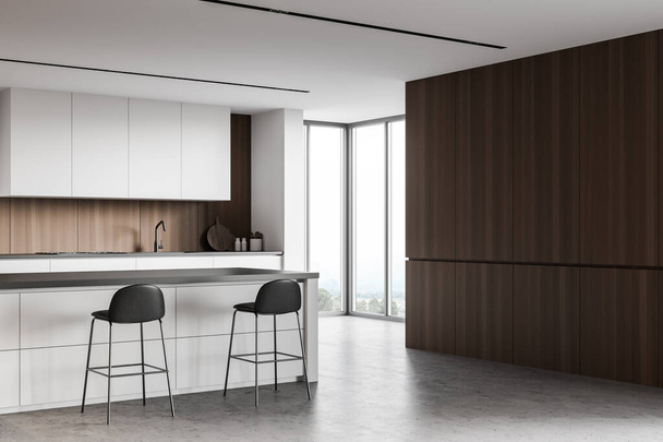 Corner of modern kitchen with white and wooden walls, concrete floor, white cupboards and countertops with built in appliances and comfortable bar with stools. Window with blurry view. 3d rendering - Photo, Image