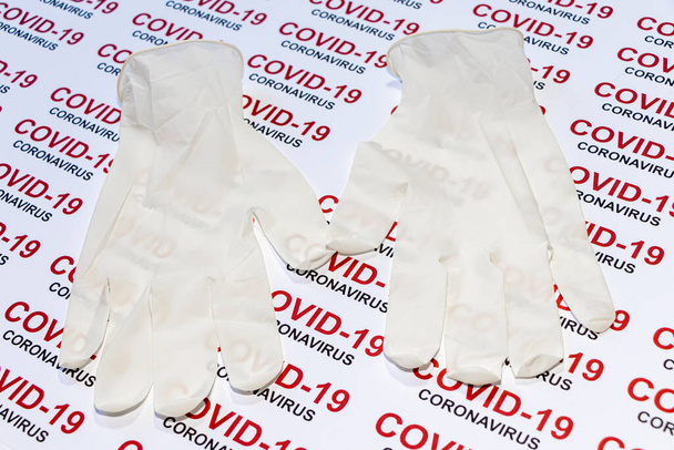 Covid-19の背景に医療用滅菌手袋。コロナウイルス保護の概念. - 写真・画像