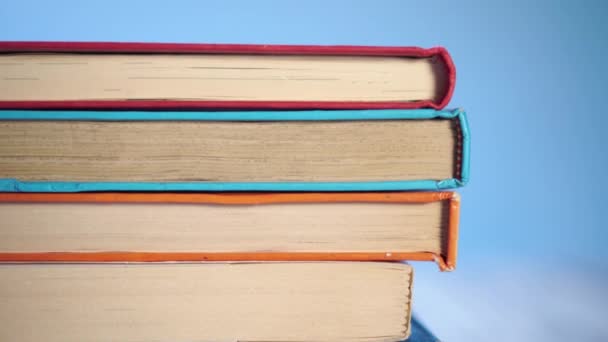 pile de vieux livres en couverture dure et douce sur un fond bleu brillant. Sur une vieille table en bois. Gros plan. La caméra descend
 - Séquence, vidéo