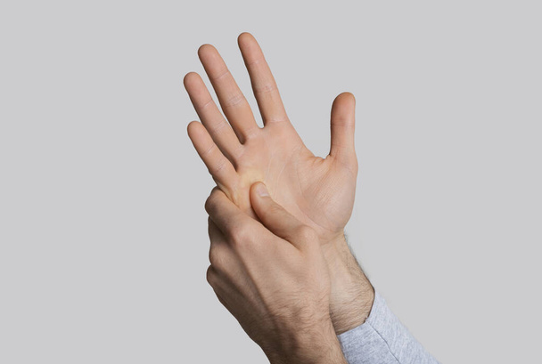 Pijnconcept. Man hand in hand gedrukt - Foto, afbeelding