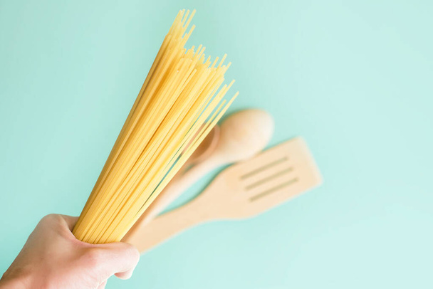 Spaghetti on a light background with tomatoes, wood spoon. Food - Valokuva, kuva
