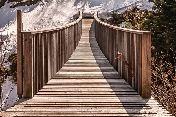 An amazing view of a wooden footbridge under sunlight - Photo, Image