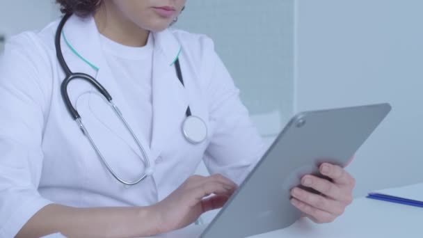 Female doctor typing on tablet, reading patient's information online, diagnosis - Imágenes, Vídeo