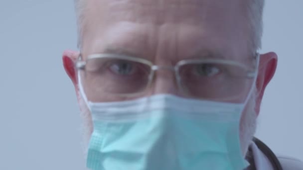 Qualified doctor in eyeglasses and mask examining patient, medical check up - Filmagem, Vídeo
