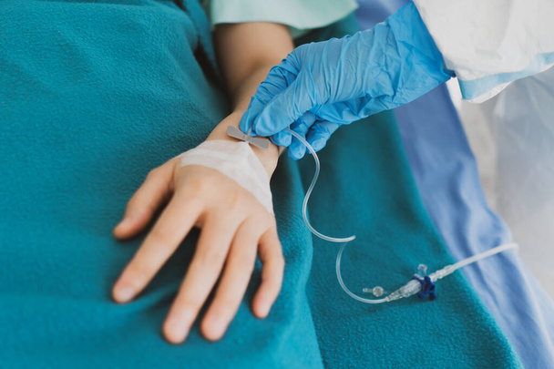 primer plano de imagen del médico que usa guantes que le dan líquido intravenoso al paciente crítico con infección por covid-19 o coronavirus. concepto médico (fouus en la mano del médico
) - Foto, Imagen