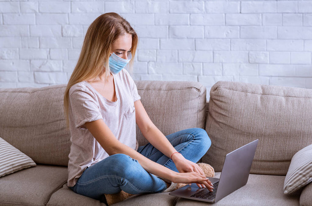 Mujer con máscara de protección médica trabajando desde casa en el ordenador
 - Foto, imagen