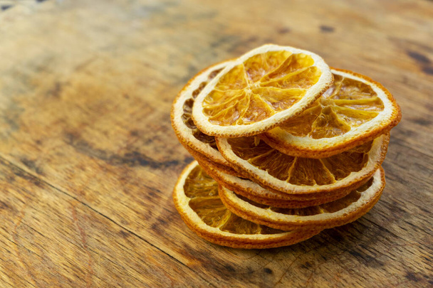 thuisvoorbereiding. gesneden gedroogde sinaasappel, plakjes, natuurlijke vruchtenchips zonder suiker en specerijen - Foto, afbeelding