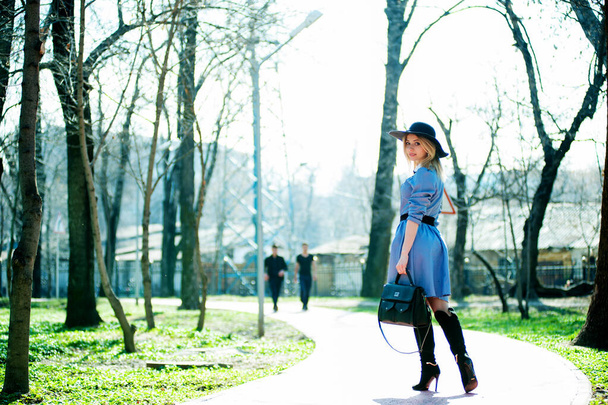 привлекательная молодая блондинка позирует на фоне зеленого парка
 - Фото, изображение