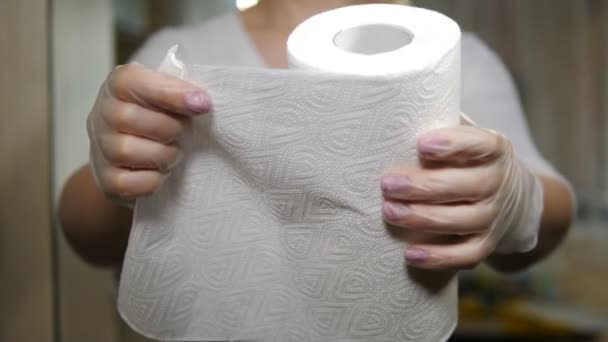 Nerozpoznatelná žena strhává z role kus papírového ručníku. Kuchyňské potřeby. Ženské ruce si berou kus bílého kuchyňského ručníku. Koncept zpracování, čištění a sterilizace. 4 k výstřel - Záběry, video