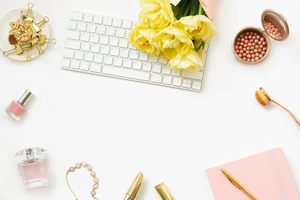 Workplace of a fashion blogger with a bouquet of yellow spring tulips. Flat lay for an online cosmetics store. - Photo, Image