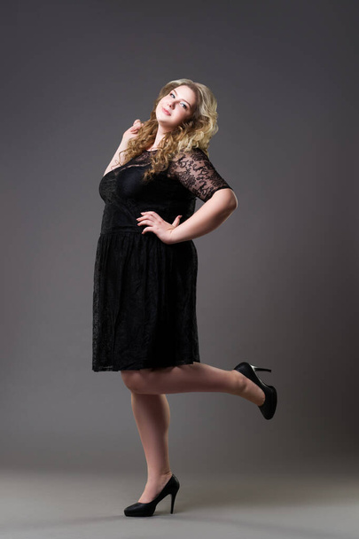 Plus size fashion model in black dress, fat woman on gray background, body positive concept - Fotoğraf, Görsel
