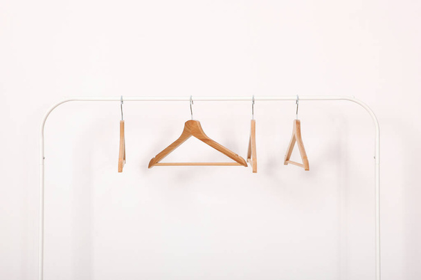 empty clothes hangers on a wardrobe rack on a light background. - Photo, Image