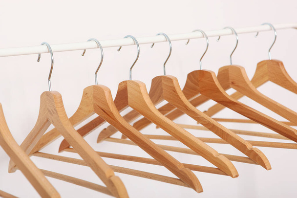 empty clothes hangers on a wardrobe rack on a light background. - Foto, imagen