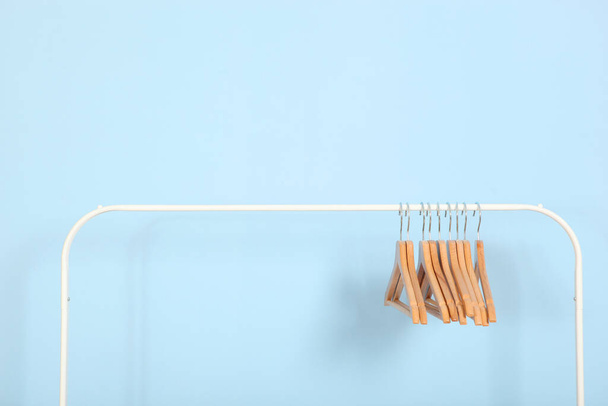 empty clothes hangers on a wardrobe rack on a colored background. - Photo, Image