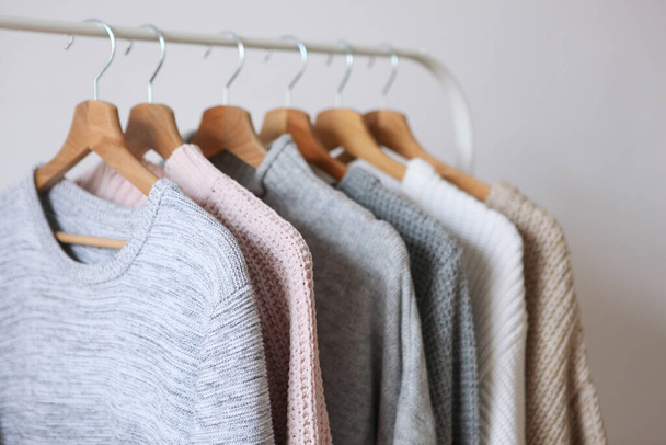 Warme Pullover auf einem Kleiderbügel vor hellem Hintergrund. Herbst, Winterkleidung. - Foto, Bild