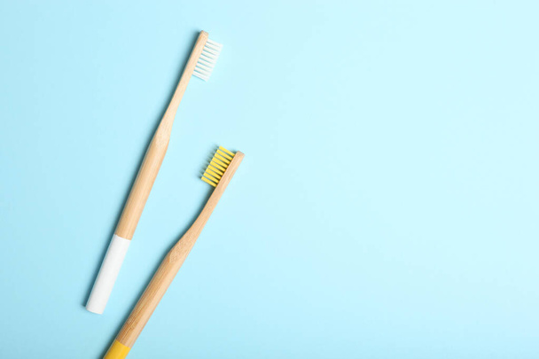 natural bamboo toothbrushes on a colored background top view. Oral and dental care. - 写真・画像