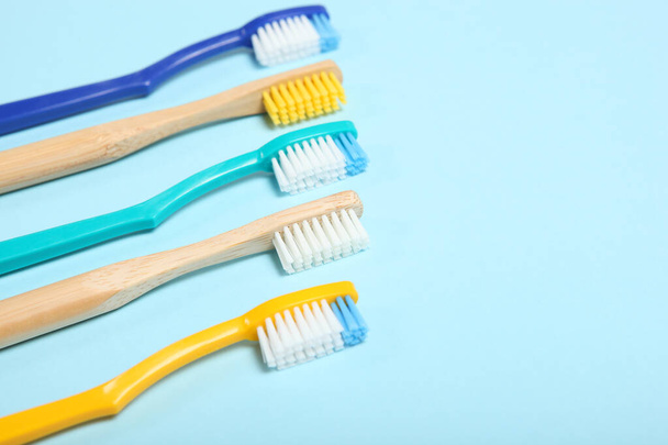 φυσικό μπαμπού οδοντόβουρτσες και πλαστικό σε έγχρωμο φόντο πάνω όψη. - Φωτογραφία, εικόνα