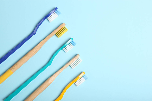 natural bamboo toothbrushes and plastic on a colored background top view. - Photo, Image