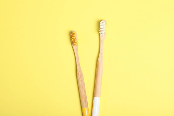 escovas de dentes de bambu naturais em uma vista superior de fundo colorido. Cuidados orais e odontológicos
. - Foto, Imagem