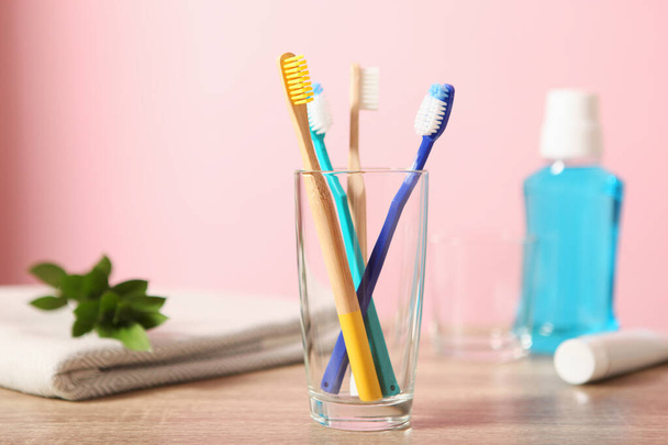 Cepillos de dientes naturales de bambú y plástico sobre la mesa
. - Foto, Imagen