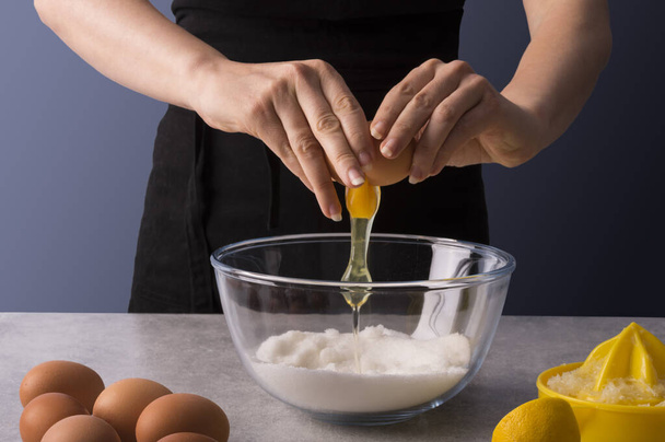 Female baker hands making dough for homemade sweet bread. Fresh and dry ingredients of lemons and oranges on stone grey table. Culinary classes or recipe concept. - Φωτογραφία, εικόνα