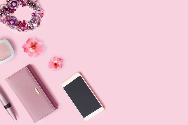  Cartera de cuero, pulsera, lápiz labial y nuevo teléfono inteligente sobre fondo rosa brillante. Hermosa flor
 - Foto, Imagen