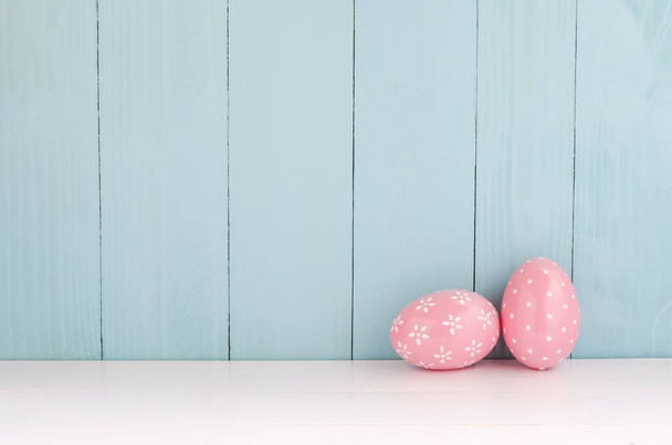 Pink color of cute easter eggs on white and blue wooden background with vintage tone - Foto, Bild
