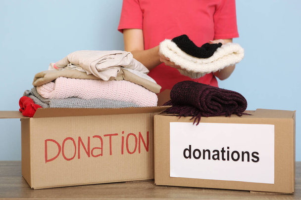 Kız bağış malzemelerinin olduğu bir kutuya koyar. Gönüllü olmak  - Fotoğraf, Görsel