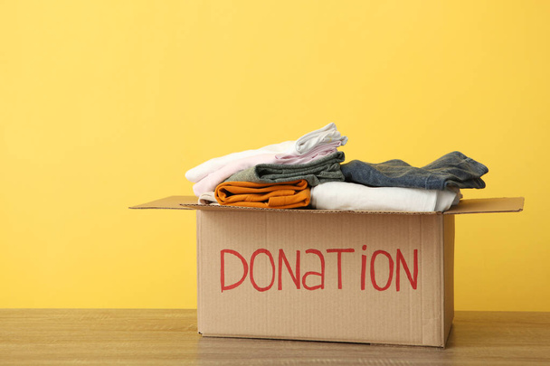 cajas con donaciones con las cosas necesarias en la mesa sobre un fondo de color. Caridad, voluntariado
. - Foto, imagen