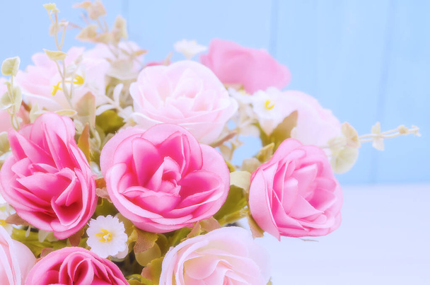 Close up of Pastel Umělé růžové růže svatební kytice na modrém dřevěném pozadí s měkkým vinobraní tón - Fotografie, Obrázek