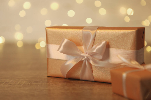 Gift boxes in gold packaging on a shiny background. Holiday, give, Christmas, birthday, New Year, mother's day. - Valokuva, kuva