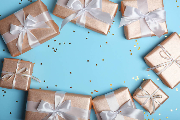 Geschenke in Goldverpackung auf farbigem Hintergrund mit Platz für Text von oben. Geburtstag, Weihnachten, Neujahr, Muttertag, 8. März, Valentinstag - Foto, Bild