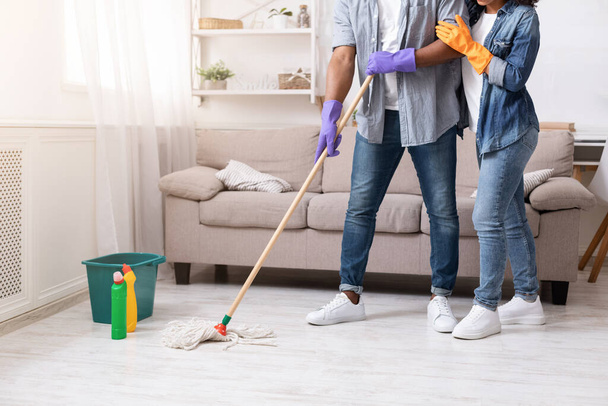 Compiti domestici. Irriconoscibile afro-americano coppia mopping piano a casa insieme
 - Foto, immagini