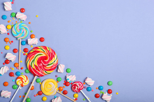 Caramelos y dulces en una vista superior de fondo de color con lugar para el texto
. - Foto, imagen