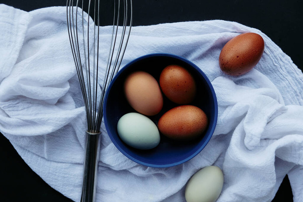 Homestead organic eggs with whisk and towel from top view for baking concept. - Photo, image