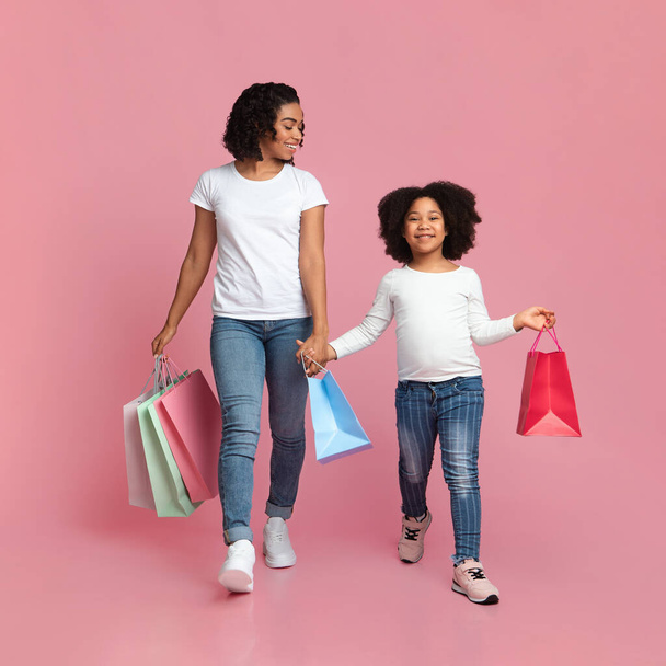 Cheerful African Mother And Daughter Walking With Shopper Bags And Smiling - Φωτογραφία, εικόνα