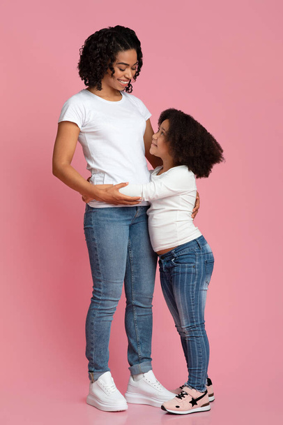 Náklonnost k matce. Malá černošky dívka objímající její maminka s láskou - Fotografie, Obrázek